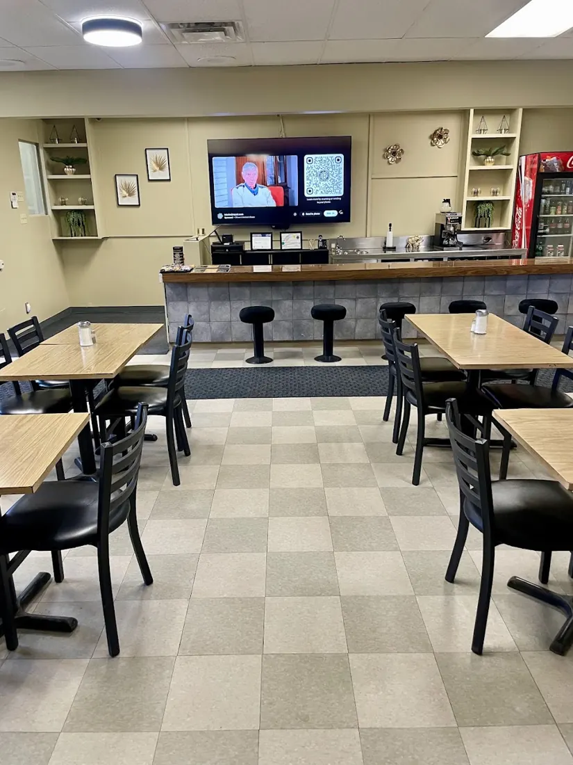 Dining room with wooden tables, checkered floor and a counter with stools