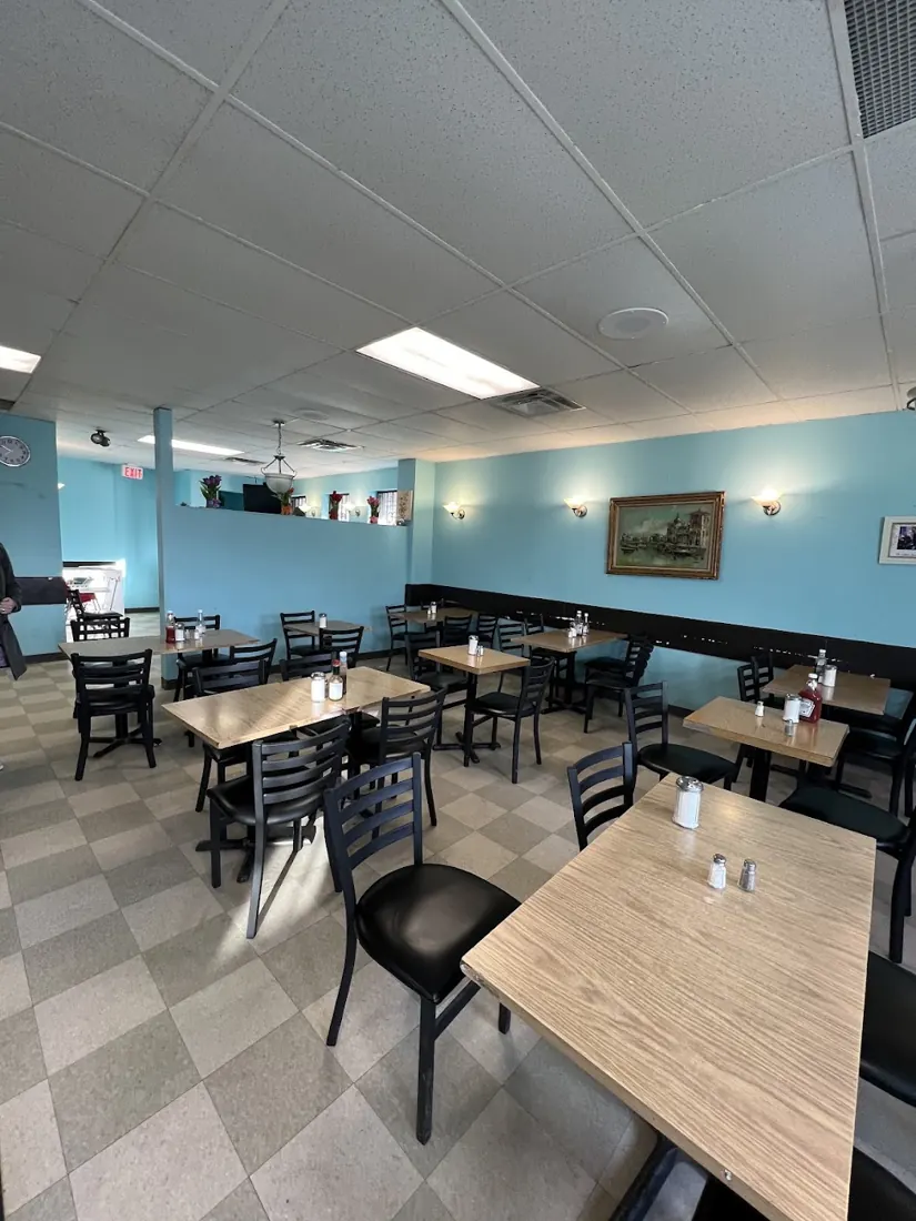 A second view of the diner's seating area with blue walls and wooden tables